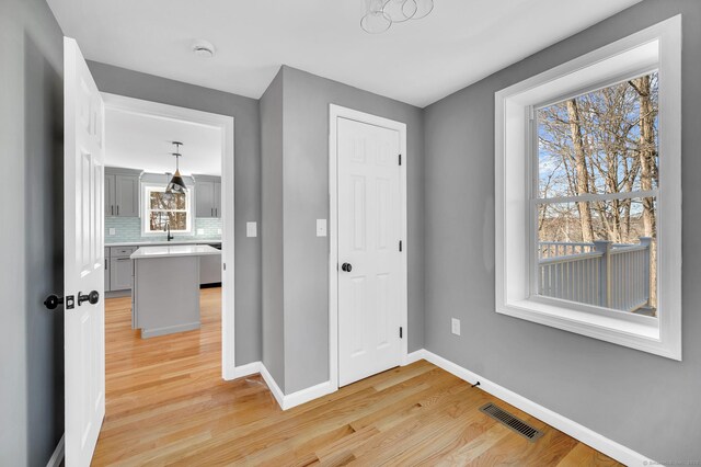 foyer with visible vents, light wood-style flooring, and baseboards