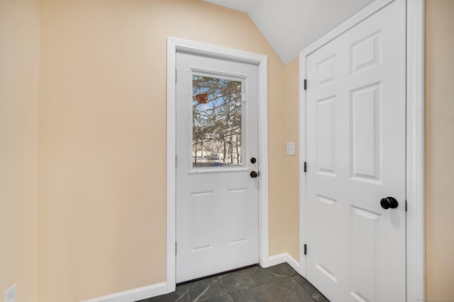 doorway with vaulted ceiling and baseboards