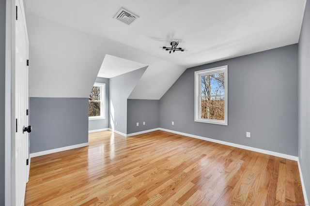 additional living space with a healthy amount of sunlight, visible vents, and light wood finished floors
