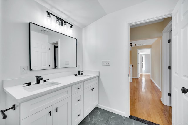 bathroom with visible vents, a sink, baseboards, and double vanity