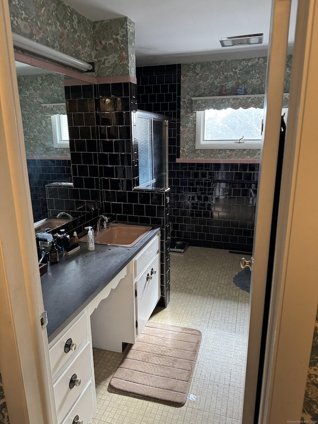 full bath featuring tile walls, visible vents, an enclosed shower, vanity, and tile patterned flooring