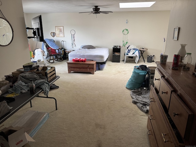 bedroom with carpet floors, a skylight, and a ceiling fan