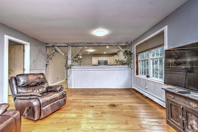 living room with a baseboard heating unit and light wood finished floors