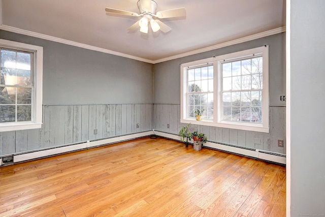 empty room featuring a ceiling fan, wood-type flooring, crown molding, and baseboard heating