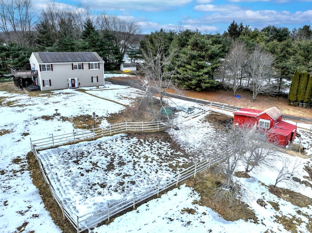 snowy yard featuring fence and an outbuilding