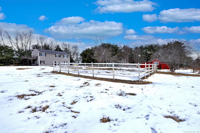 yard covered in snow with a detached garage and fence