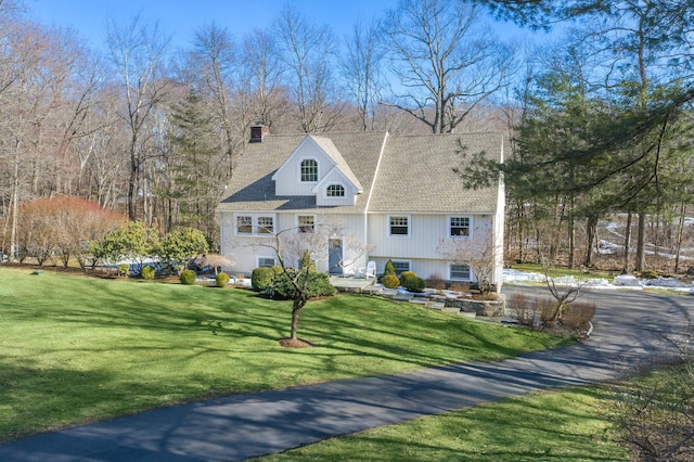 view of front of house with a chimney and a front lawn