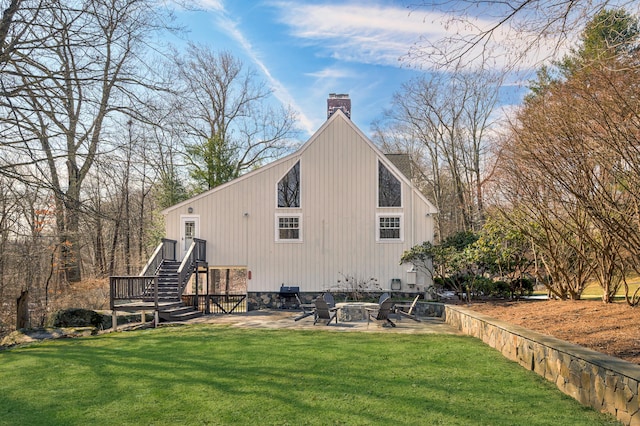 rear view of house featuring a patio area, a lawn, a chimney, and a fire pit