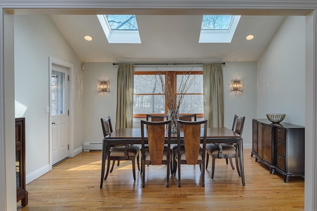 dining space featuring lofted ceiling, a baseboard heating unit, and a wealth of natural light