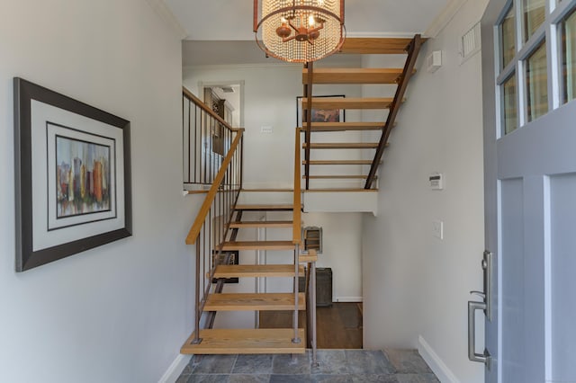 staircase with a chandelier, stone finish floor, and baseboards