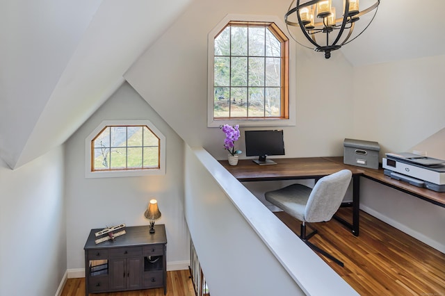 home office featuring vaulted ceiling, an inviting chandelier, wood finished floors, and baseboards