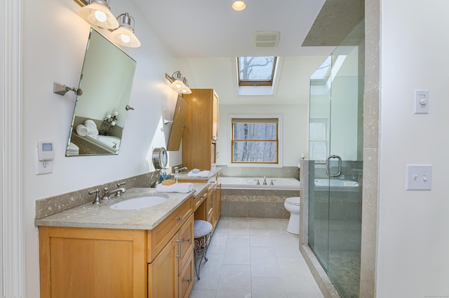 full bathroom with a skylight, a stall shower, tile patterned floors, a garden tub, and vanity