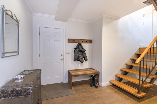 mudroom featuring crown molding, baseboards, and wood finished floors