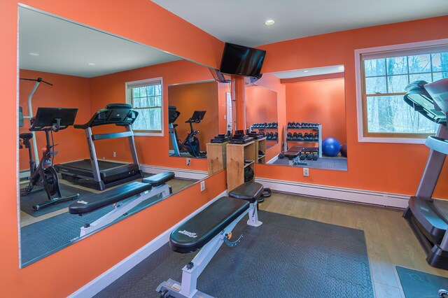 exercise area featuring baseboards, a baseboard heating unit, wood finished floors, and recessed lighting