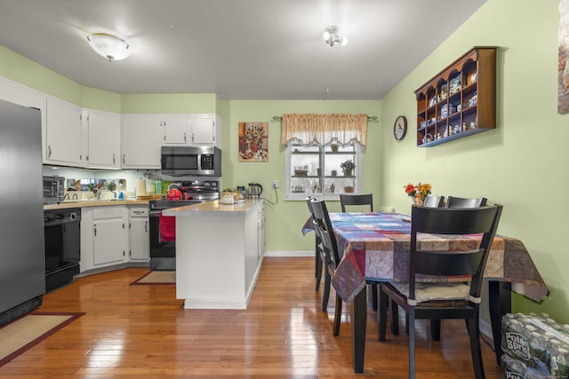 kitchen with stainless steel appliances, light wood-style flooring, and white cabinets