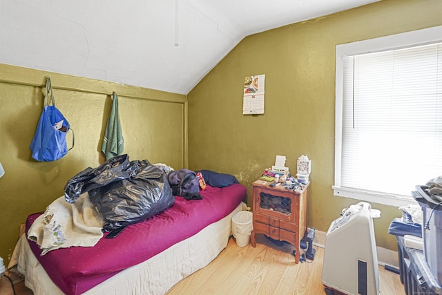 bedroom with lofted ceiling, wood finished floors, and baseboards