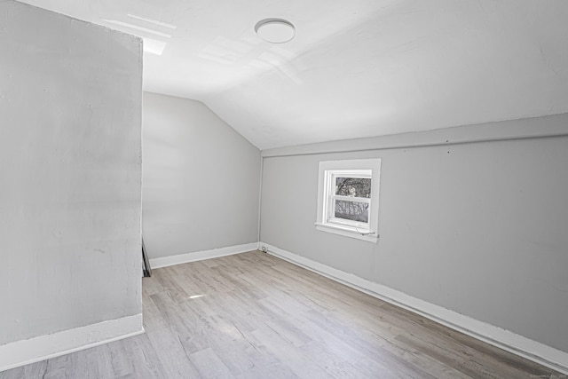 bonus room with baseboards, vaulted ceiling, and wood finished floors