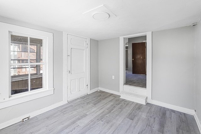 spare room featuring baseboards and wood finished floors