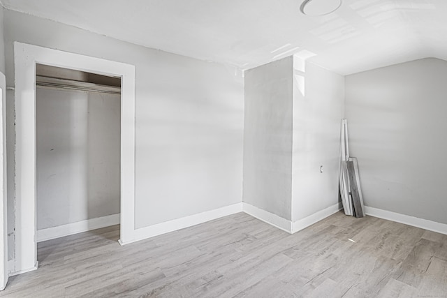 unfurnished room with vaulted ceiling, baseboards, and wood finished floors