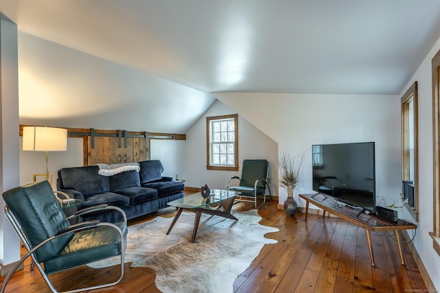 living area with baseboards, vaulted ceiling, and hardwood / wood-style flooring