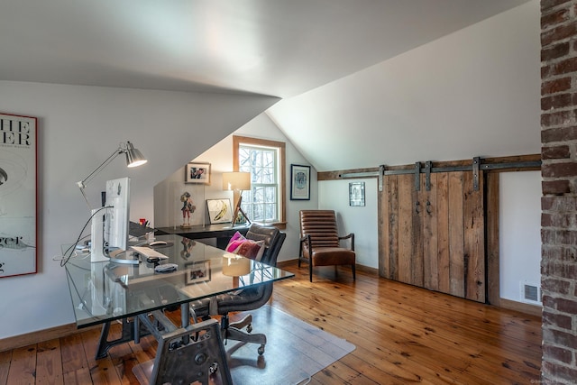 office area featuring baseboards, visible vents, wood-type flooring, and lofted ceiling