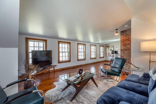 living room featuring plenty of natural light, lofted ceiling, and hardwood / wood-style flooring