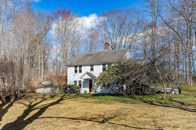 view of front of house with a front yard and a chimney