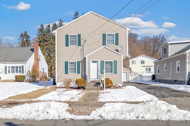 view of front of home with driveway, a garage, and fence