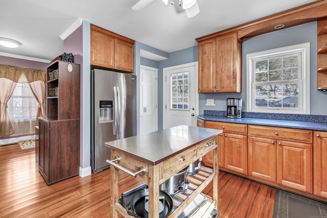 kitchen with dark countertops, wood finished floors, stainless steel refrigerator with ice dispenser, and open shelves