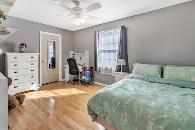 bedroom featuring light wood-style floors, baseboards, and a ceiling fan