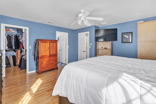 bedroom with a spacious closet, a closet, light wood-type flooring, and visible vents