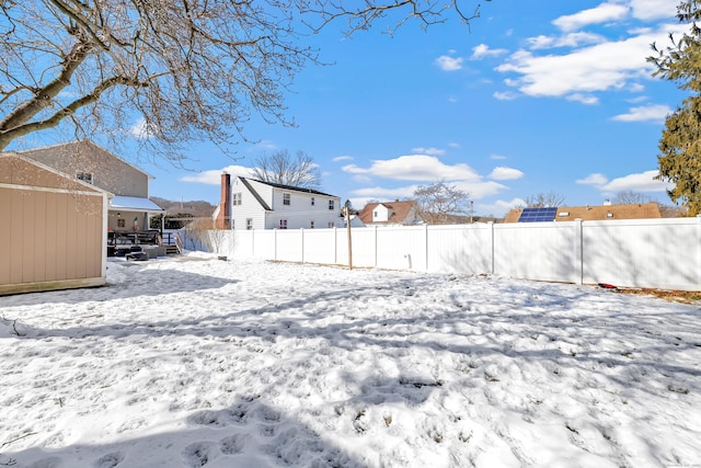 yard covered in snow featuring fence