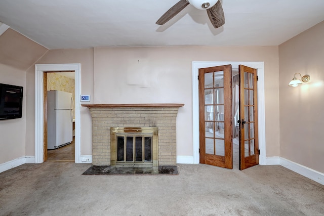 unfurnished living room featuring baseboards, carpet floors, a fireplace, french doors, and a ceiling fan