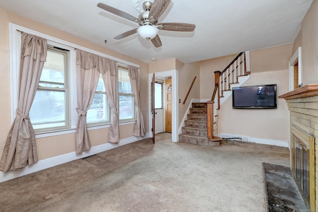 unfurnished living room with stairs, carpet, baseboards, and ceiling fan