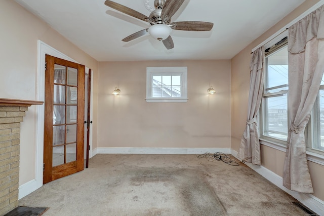 unfurnished room featuring visible vents, carpet floors, baseboards, and a ceiling fan