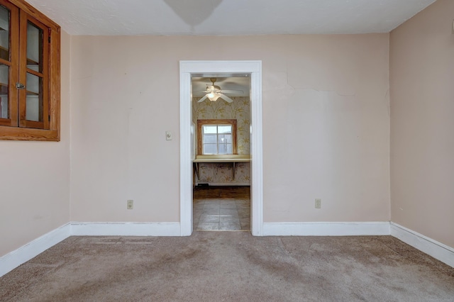 spare room with baseboards, carpet, and ceiling fan