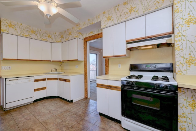 kitchen featuring wallpapered walls, white dishwasher, under cabinet range hood, and range with gas stovetop