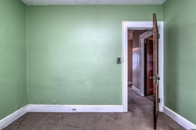 spare room featuring baseboards and carpet