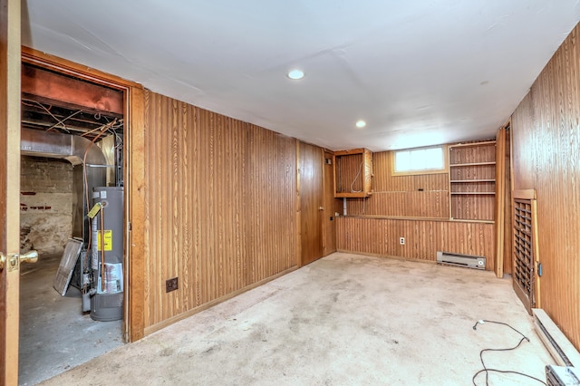 below grade area with gas water heater, baseboard heating, and wooden walls