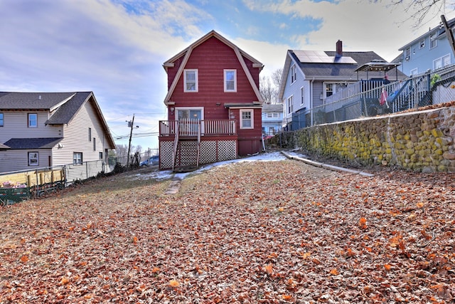 back of house featuring a deck, a fenced backyard, a gambrel roof, and a residential view