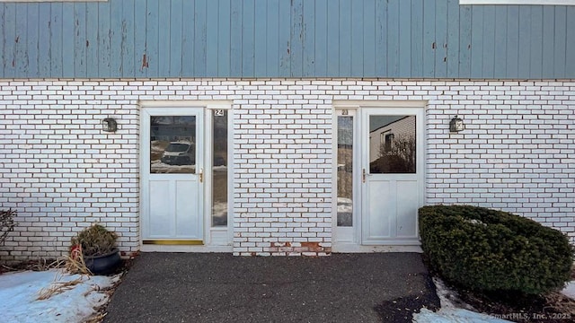 view of exterior entry with brick siding