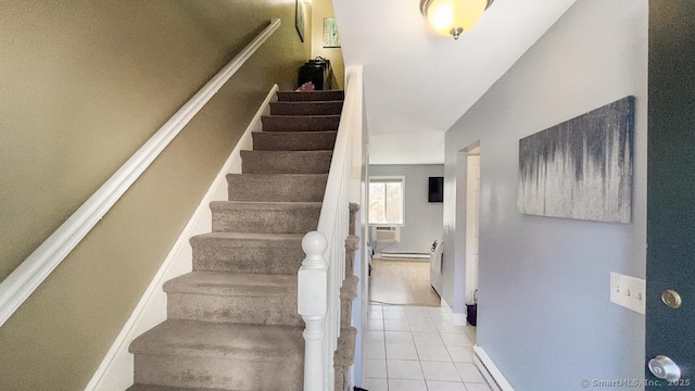 stairway featuring lofted ceiling, tile patterned flooring, and baseboards