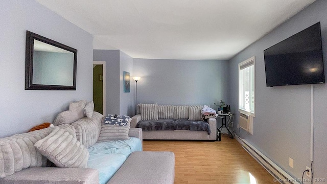 living area with light wood-style flooring, baseboard heating, and a wall mounted air conditioner