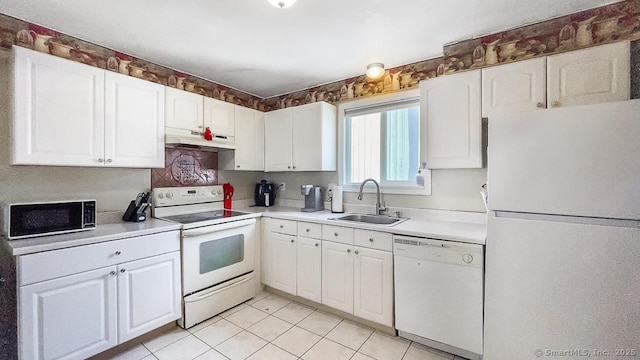 kitchen featuring light countertops, white cabinets, a sink, white appliances, and under cabinet range hood