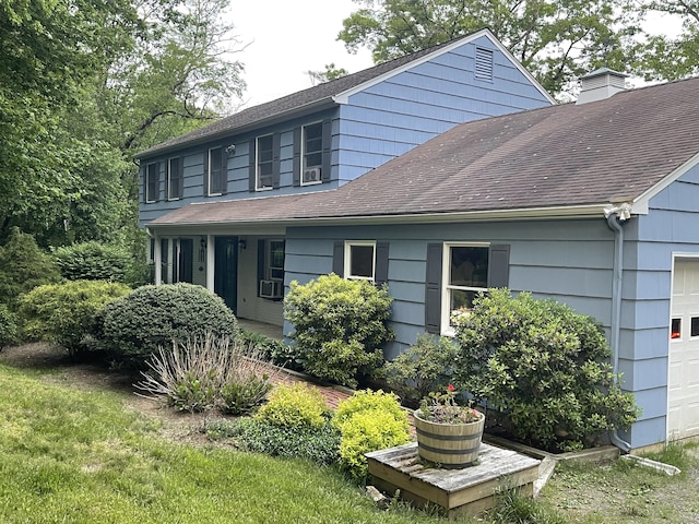 view of property exterior with cooling unit, roof with shingles, a chimney, and a garage
