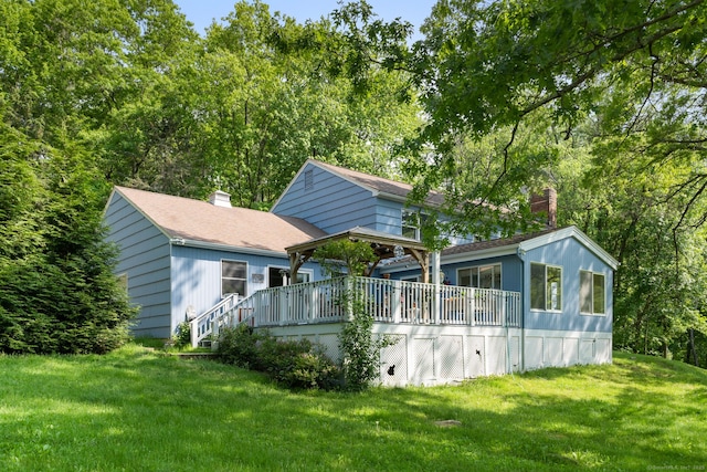 back of house featuring a yard, a deck, and a chimney
