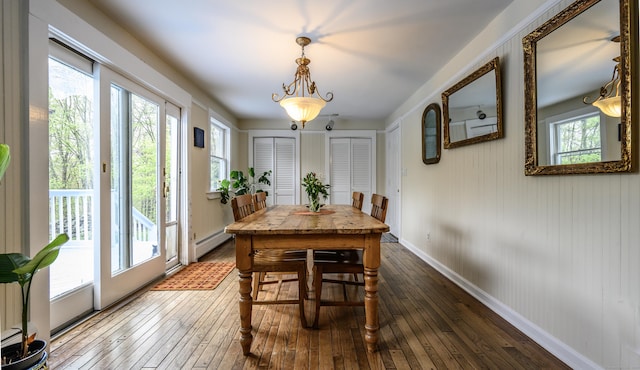 dining area featuring baseboards, baseboard heating, and hardwood / wood-style flooring