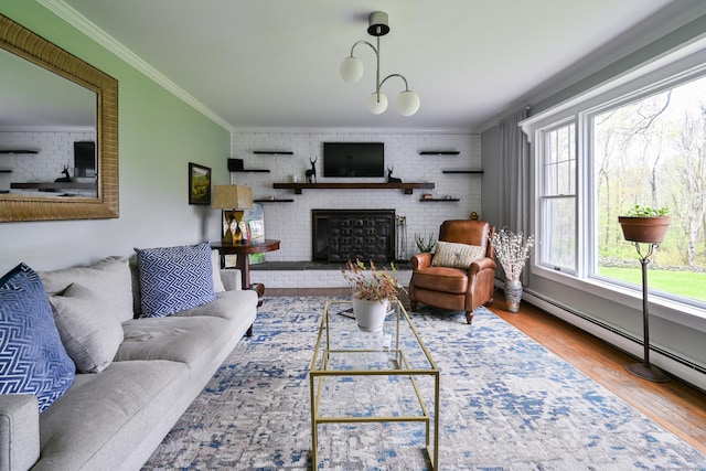 living room featuring wood finished floors, crown molding, a baseboard radiator, a brick fireplace, and brick wall