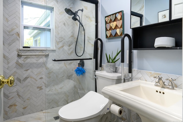 bathroom featuring a stall shower, tile walls, toilet, and a sink
