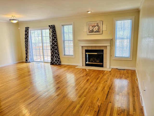 unfurnished living room featuring a fireplace, wood finished floors, baseboards, and ornamental molding